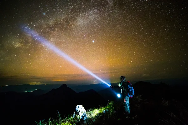 Young man Standing on Mountain with night sky — Stock Photo, Image