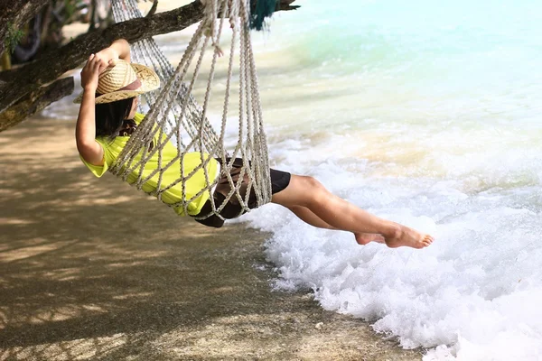 Meisje, zittend op het bed naast het strand — Stockfoto