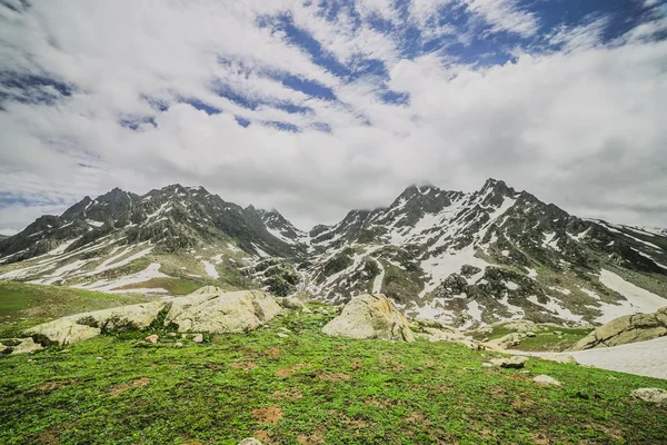 Snow mountain s zeleným polem — Stock fotografie