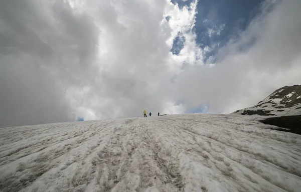 Skupina turistů chůze mezi zimní pláň — Stock fotografie