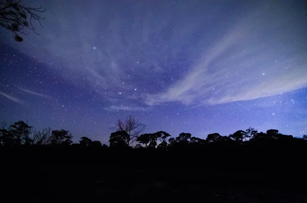Blauwe donkere nachtelijke hemel met veel sterren — Stockfoto