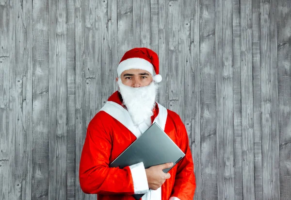 一个装扮成圣诞老人的白人年轻人被激怒了 他怀里拿着一台电脑 复制上面的空间 — 图库照片