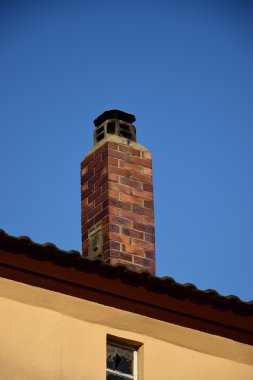 Mavi tuğla duvardaki eski baca.