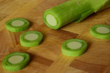 Bir kesme tahtası üzerinde adet pırasa sapı kesilmiş