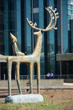 onun arkasında oturan bir çocuk bir geyik featuring heykeli