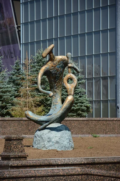 Una estatua de bronce con un músico tocando un instrumento similar a una viola — Foto de Stock