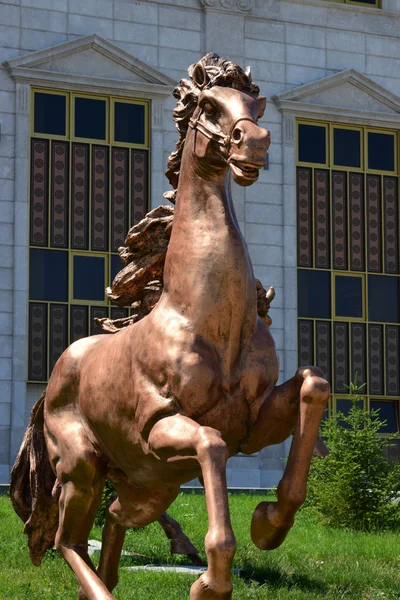 Bronze statue featuring a racing horse — Stock Photo, Image