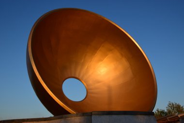 ortasında delik olan bir heykel-bronz fincan şeklinde