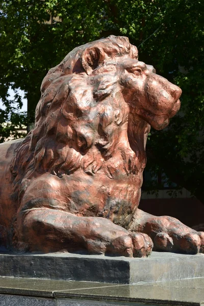 横になっているライオンを備えた銅像の頭部 — ストック写真