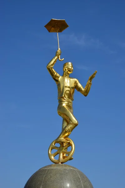 Gilded statue of a circus man on a monocycle in Astana