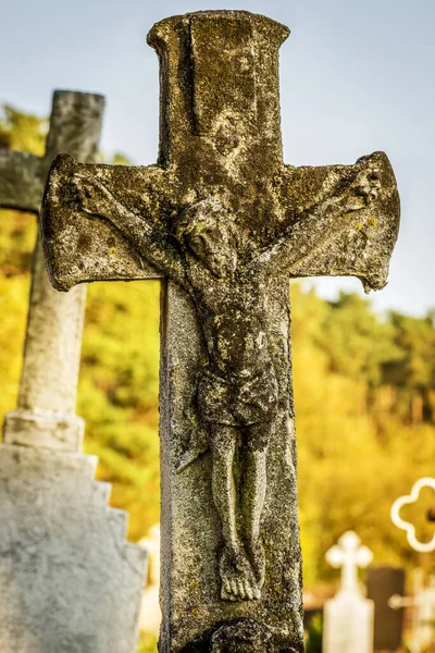 Statue of antique cross with the crucified Christ on the old 19th century cemetery. Ukraine..