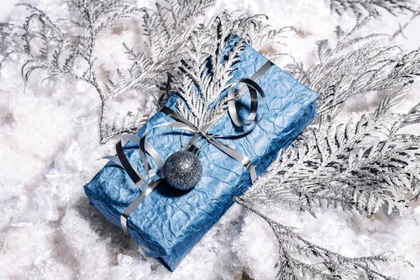 Krásný ruční práce Nový rok dárky ve stříbrné modré barvě. Vánoční přání se stříbrným a modrým pozadím. Vánoční ozdoba s borovicí, jedlí a dárkovými krabicemi. Zavřít, — Stock fotografie