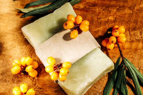 Handmade Natural sea buckthorn soap with berries close-up on a wooden background. — Stock Photo, Image
