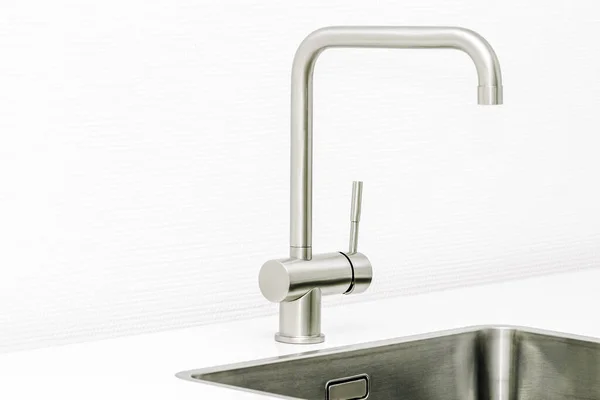 Close up of a worktop of a modern kitchen and the steel sink and water tap.. — Stock Photo, Image