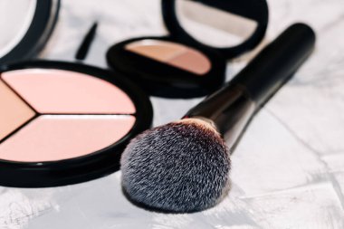 Açık beton arka planda makyaj fırçası ve toz. Moda arka planı, aksesuarlar.