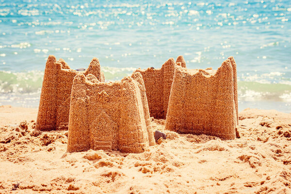 Sand castle with towers on the beach with view on the sea. Holiday concept with sand castle, Travel concept..