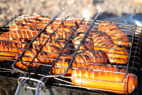 Izgarada kızarmış sosis var. Piknikte yemek