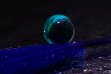 Mavi tüy cam bir topun yanında yatıyor. Yüksek kalite fotoğraf