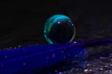 Mavi tüy cam bir topun yanında yatıyor. Yüksek kalite fotoğraf