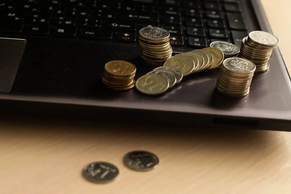 metal coins lie on the laptop\'s keyboard. High quality photo