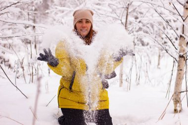 Kar atan güzel seksi kız. Karda ağaçların arasında