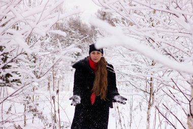 Kar atan güzel seksi kız. Karda ağaçların arasında