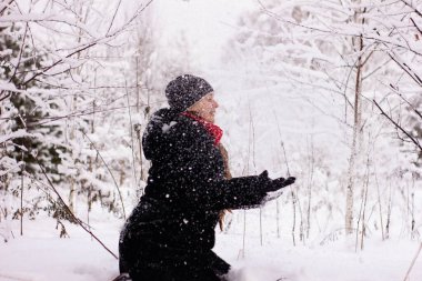 Kar atan güzel seksi kız. Karda ağaçların arasında