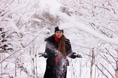 Kar atan güzel seksi kız. Karda ağaçların arasında