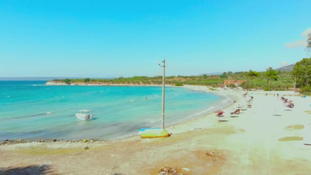 トルコのディディムで風の強い夏の日に白いビーチとターコイズブルーの水の風景の空中ビュー トルコのエーゲ海沿岸の白いビーチでカラフルな傘 — ストック動画