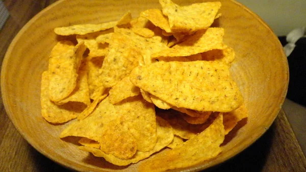 Mexican nachos chips in a bowl. Tortilla or Nacho Chips for snack. Close-up view of Mexican Corn Chips Nachos on wooden background.