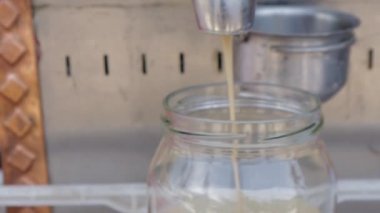 Tahini öğütücü makinesiyle susam tohumları Tahini olur. Susam kremalı tereyağına dönüşür Tahini