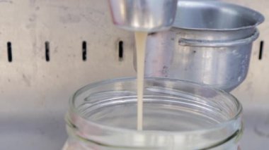 Tahini öğütücü makinesiyle susam tohumları Tahini olur. Susam kremalı tereyağına dönüşür Tahini