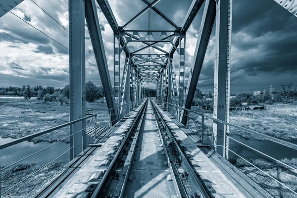 Železniční most pod bouřlivé nebe. — Stock fotografie