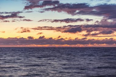 Denizin yüzeyinde gün batımı gökyüzü.