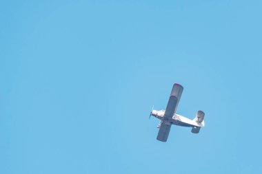 Eski bir retro uçak mavi gökyüzünde uçuyor.