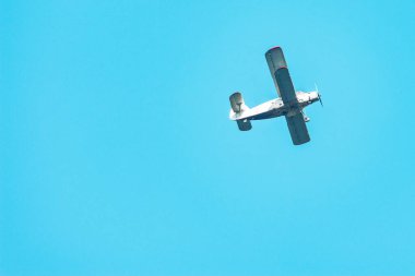 Eski bir retro uçak mavi gökyüzünde uçuyor.