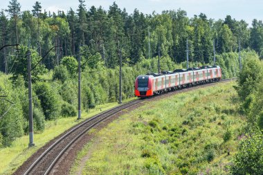 Yolcu treni yaz günü istasyona yaklaşır..