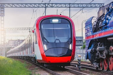 Elektrikli tren ve buharlı tren gün batımında hareket eder. Moskova. Rusya.