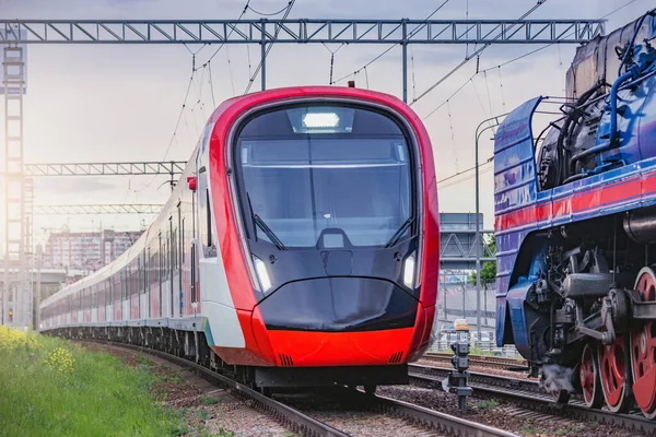 Elektrikli tren ve buharlı tren gün batımında hareket eder. Moskova. Rusya.