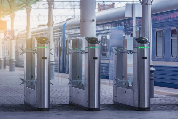 Turnstiles with electronic card readers on the platform.