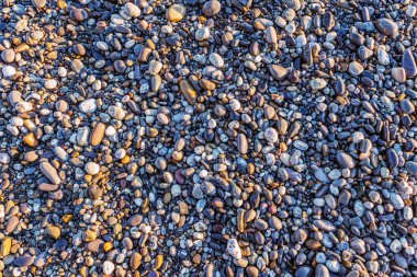 Gün batımında sahilde küçük taşlar.