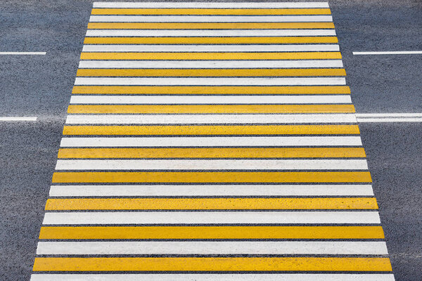 White and yellow lines on the asphalt crossroad.