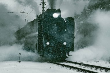 Buharlı retro tren kış akşamı istasyondan ayrılıyor..