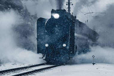 Buharlı retro tren kış akşamı istasyondan ayrılıyor..