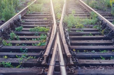 Günbatımı zamanı büyük istasyonda tren raylarda.