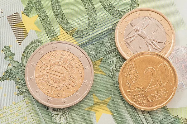 Monedas en euros sobre fondo de billetes de cien euros . — Foto de Stock