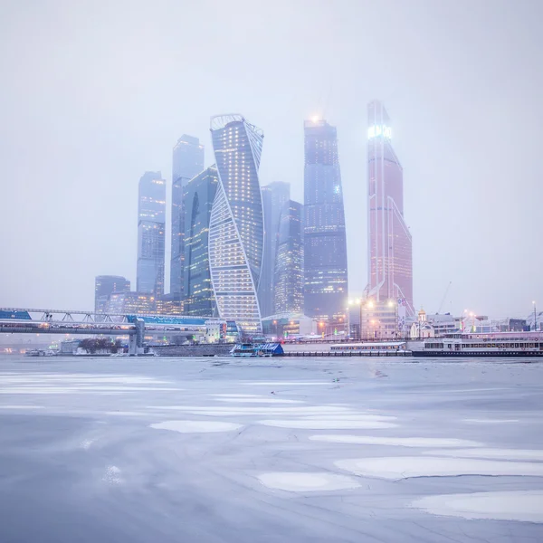 Winters aanblik van het business center onder de sneeuw en mist. — Stockfoto