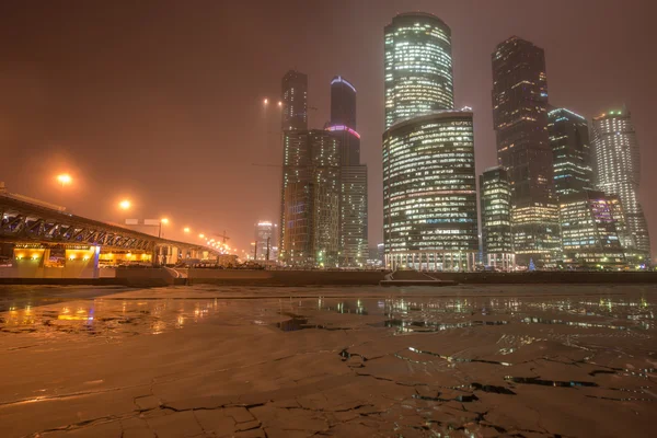 Wieczór zimowy widok centrum biznesowego w śniegu i mgła. — Zdjęcie stockowe