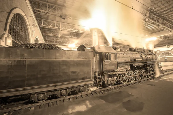 Steam train arrives to the station at night time. — Stock Photo, Image