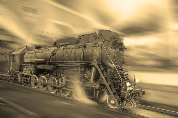 Comboio a vapor vai rápido no fundo da estação noturna . — Fotografia de Stock